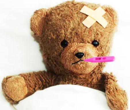 Teddy Bear who appears to be sick in bed